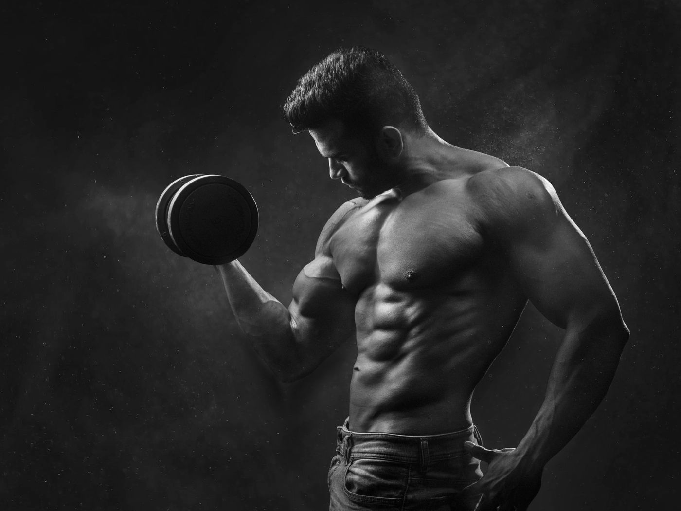 Black-and-white study of a member mid curl, chest and arm definition lit from above